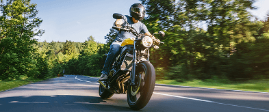 Motorista AXA en carretera con su moto